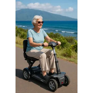 Older woman in a blue shirt riding a black Akamai Transformer folding scooter near Maui’s coastline, smiling on a sunny day.