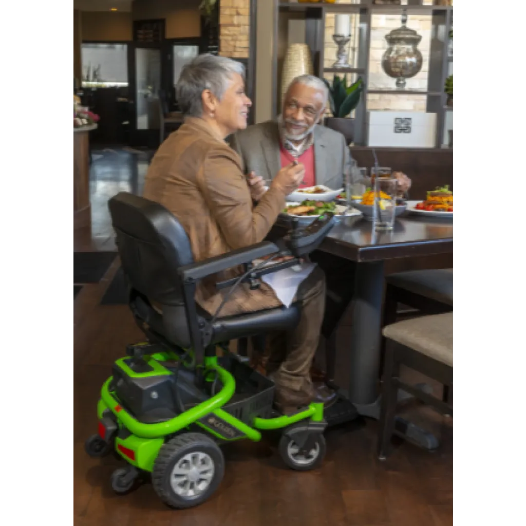 Person using a Golden Technologies LiteRider Envy electric power wheelchair from Akamai Mobility sits comfortably in a Waikoloa restaurant on the Big Island of Hawaii.